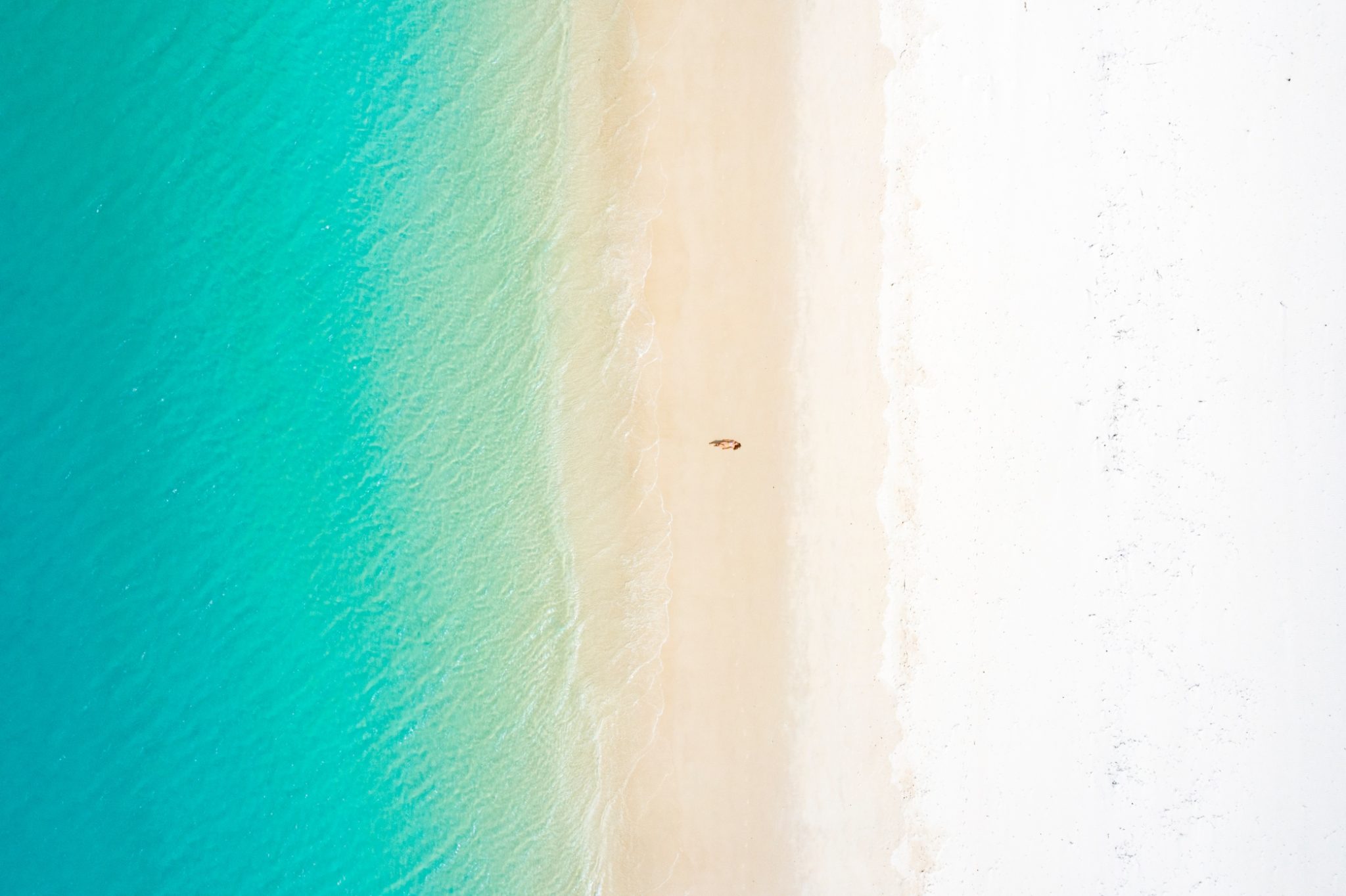 woman lying on white sand beach with turquoise waters in cancun